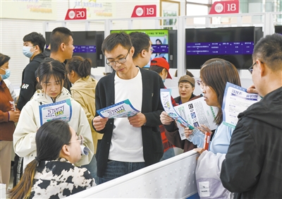 图为招聘会现场，求职者向招聘企业工作人员咨询岗位情况。戎禹仁摄