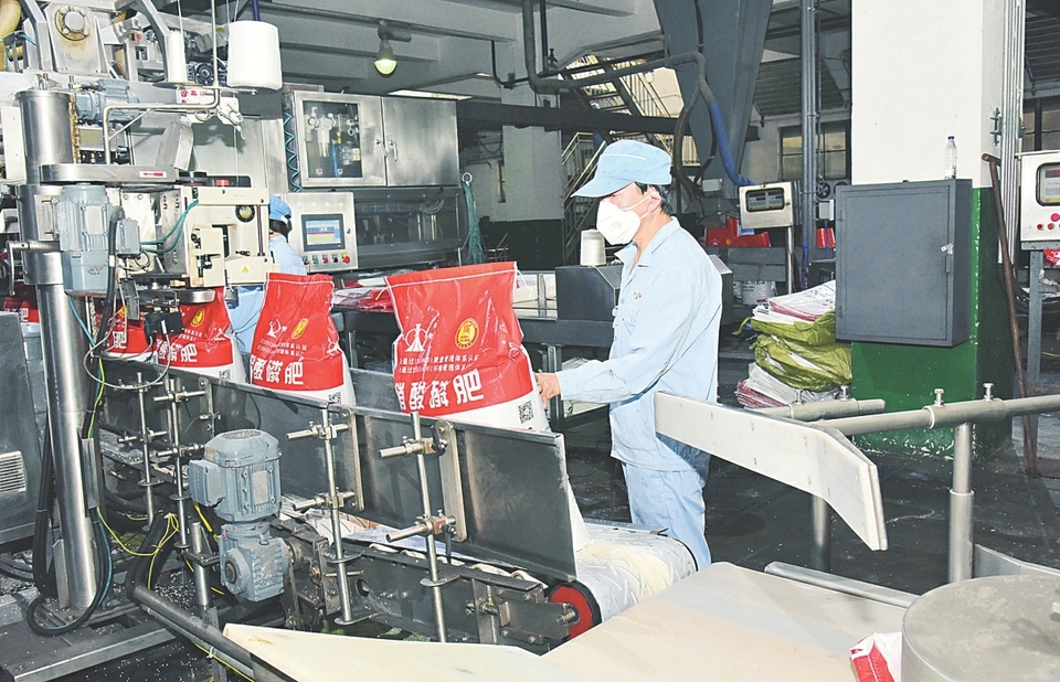 潞安化工天脊集团员工正在化肥包装线上精心作业。（王爱军 摄）