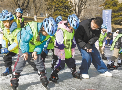图为教练向参加冬令营的少年传授滑冰技巧。戎禹仁摄