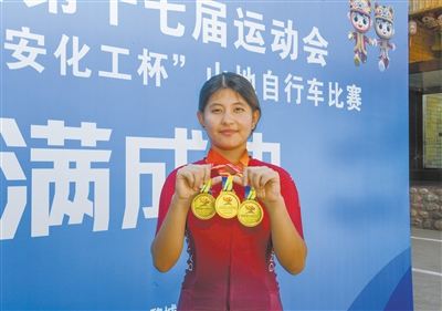 图为塔冰宁展示获得的3枚金牌。戎禹仁摄